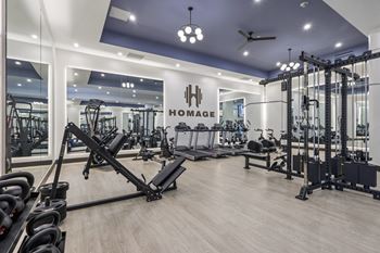 A gym with a variety of equipment including weights and cardio machines.